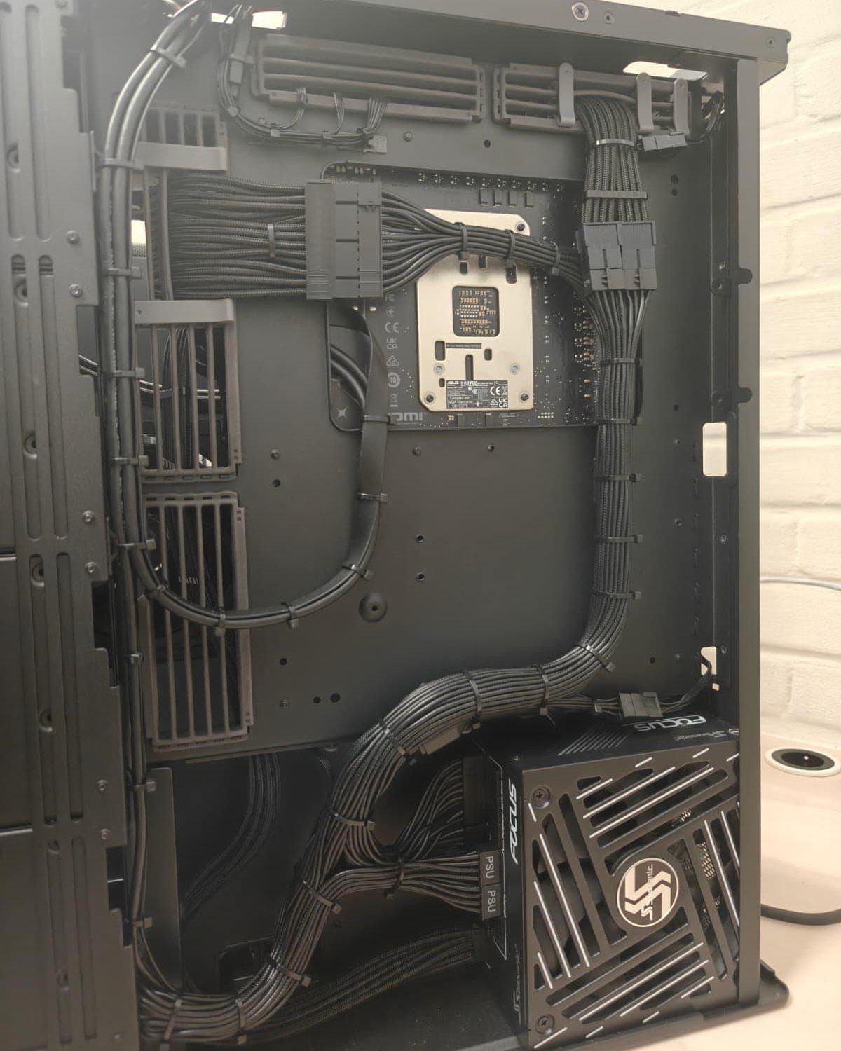 Black cables neatly bundled and routed inside a black computer case chassis.