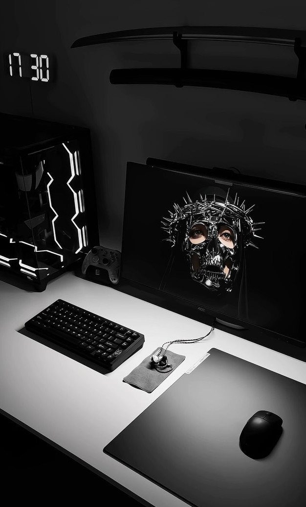 Black gaming PC with white LED lighting next to a monitor and keyboard.