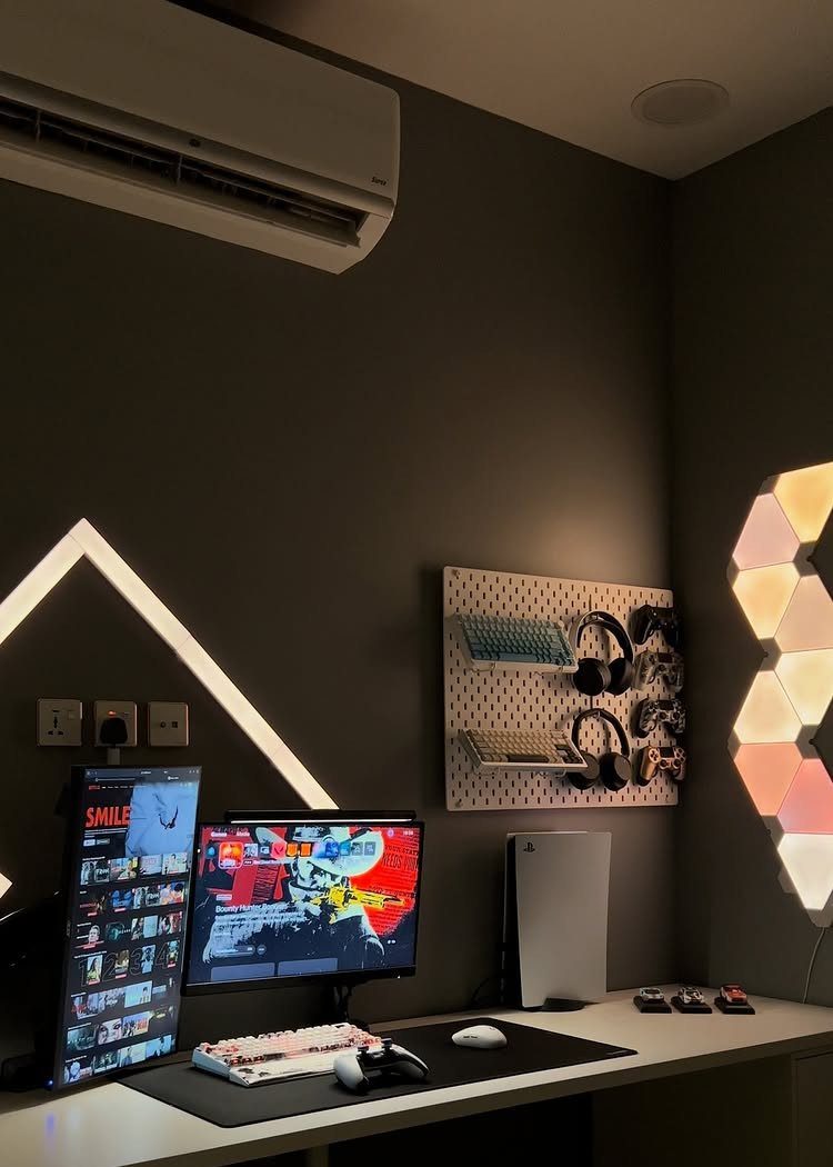 Gaming setup with white triangular LED light strips on a dark grey wall.