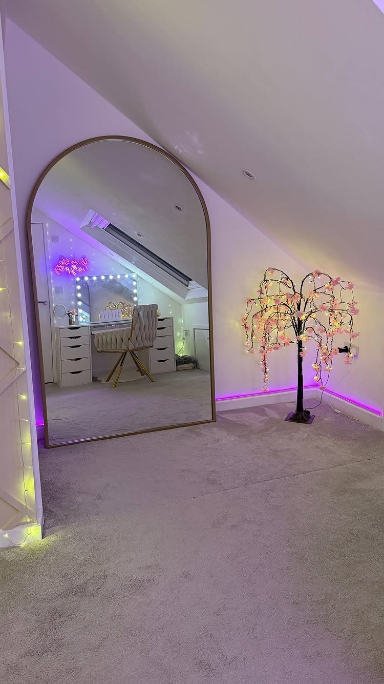 Attic bedroom with sloped ceilings, arched mirror, and a glowing cherry blossom tree.