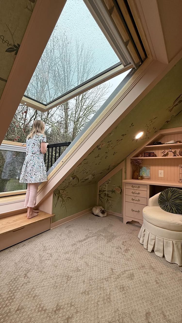 Child looking through a skylight in a cozy attic bedroom with sloped ceilings.