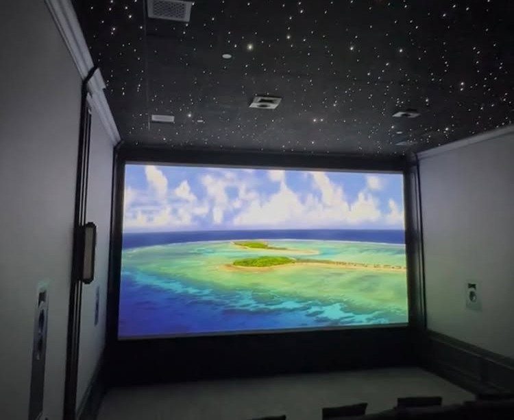 Home theater with a large projection screen and a starry night ceiling.