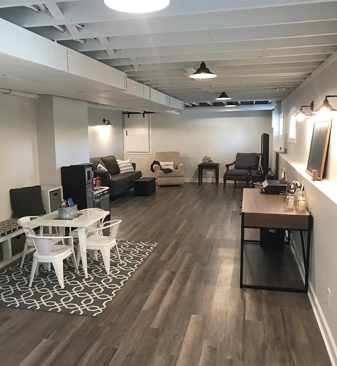 Light grey walls and white ceiling in a finished basement with office furniture.