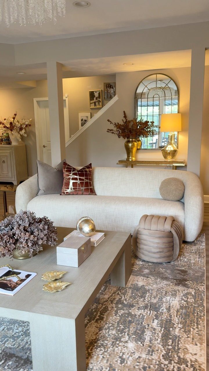 10 Basement Wall Paint Ideas to Refresh Your Space 5 Warm beige walls in a living room with a white curved sofa and gold accents.