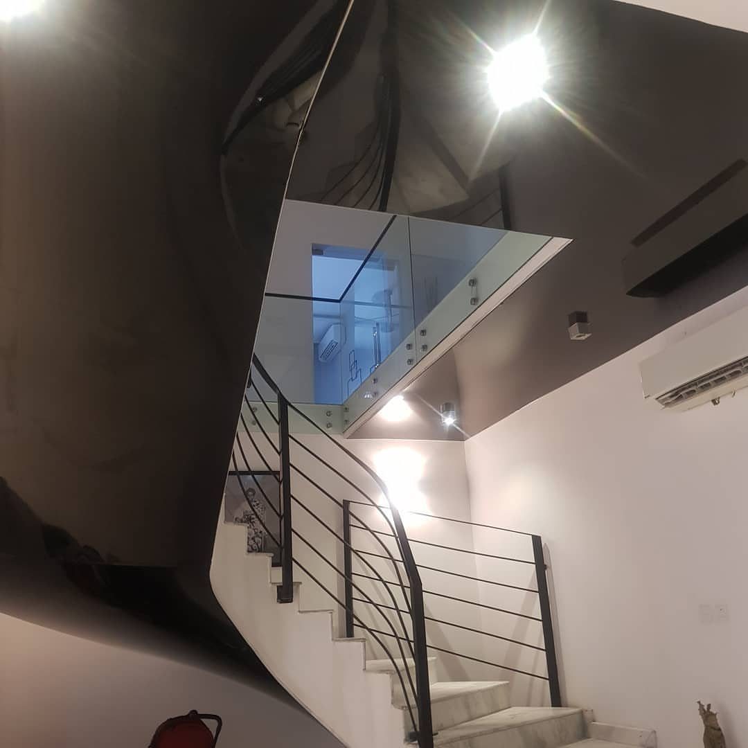 11 Black Ceiling Basement Ideas with Real Impact 10 White staircase with black railings under a glossy reflective black ceiling.