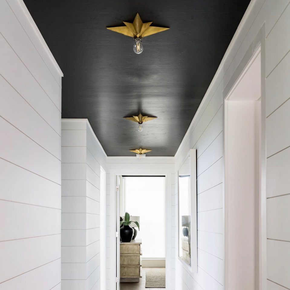 11 Black Ceiling Basement Ideas with Real Impact 3 White shiplap walls in a hallway with a contrasting matte black ceiling.