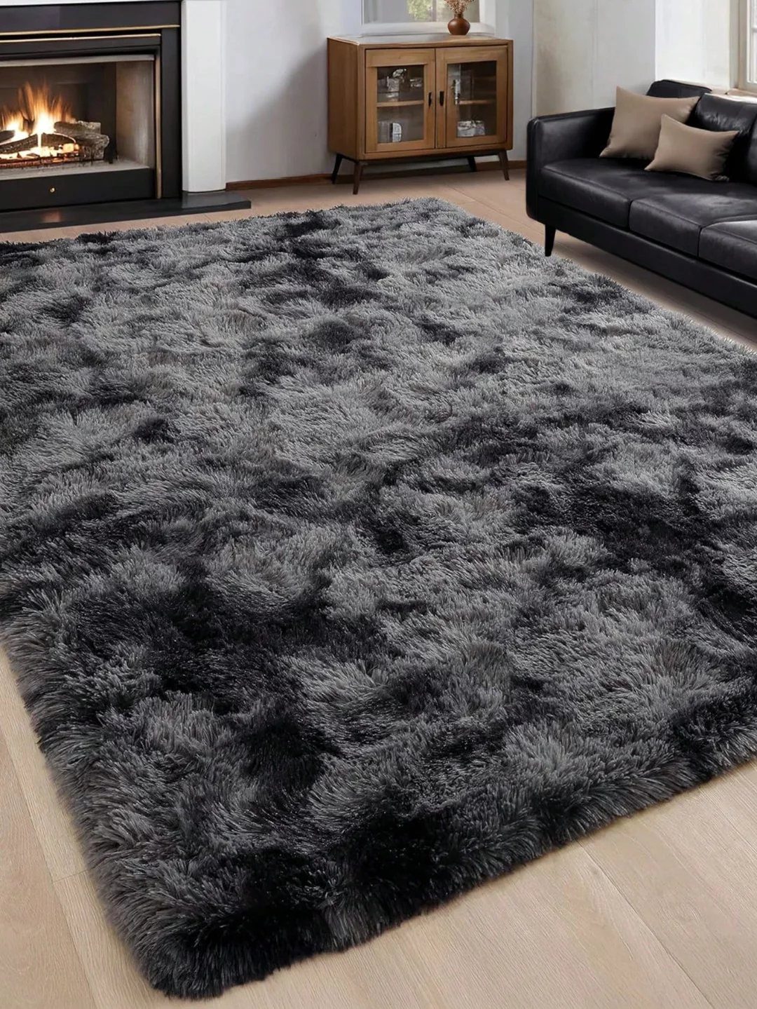 Grey shaggy area rug on a light wood floor in a cozy living room.