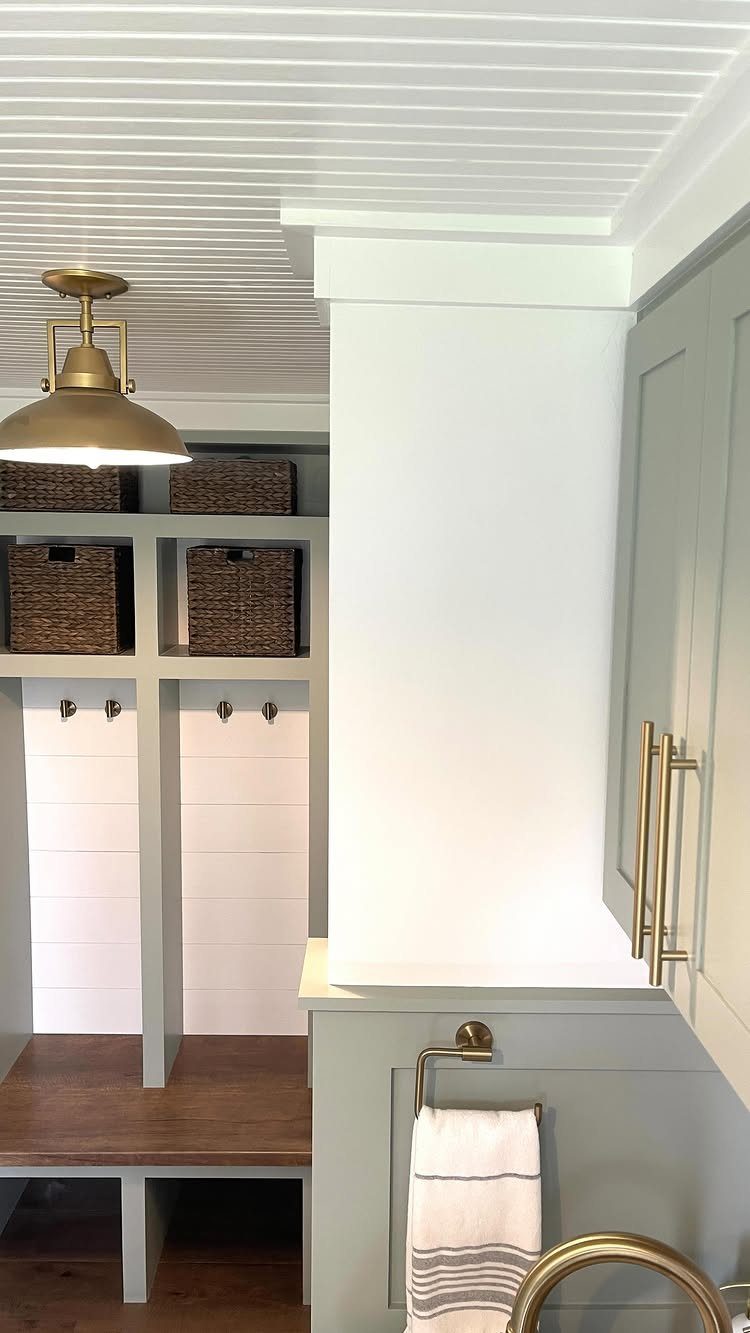 White beadboard ceiling with a gold pendant light in a modern mudroom.