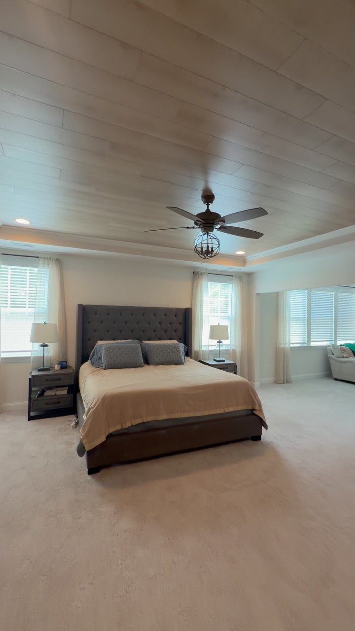 Light wood plank ceiling with a ceiling fan in a modern bedroom