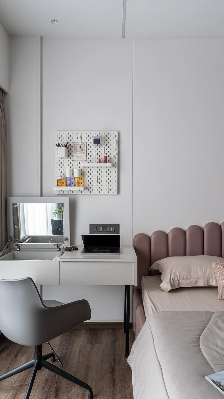White minimalist desk with a built-in drawer and a white pegboard organizer above.