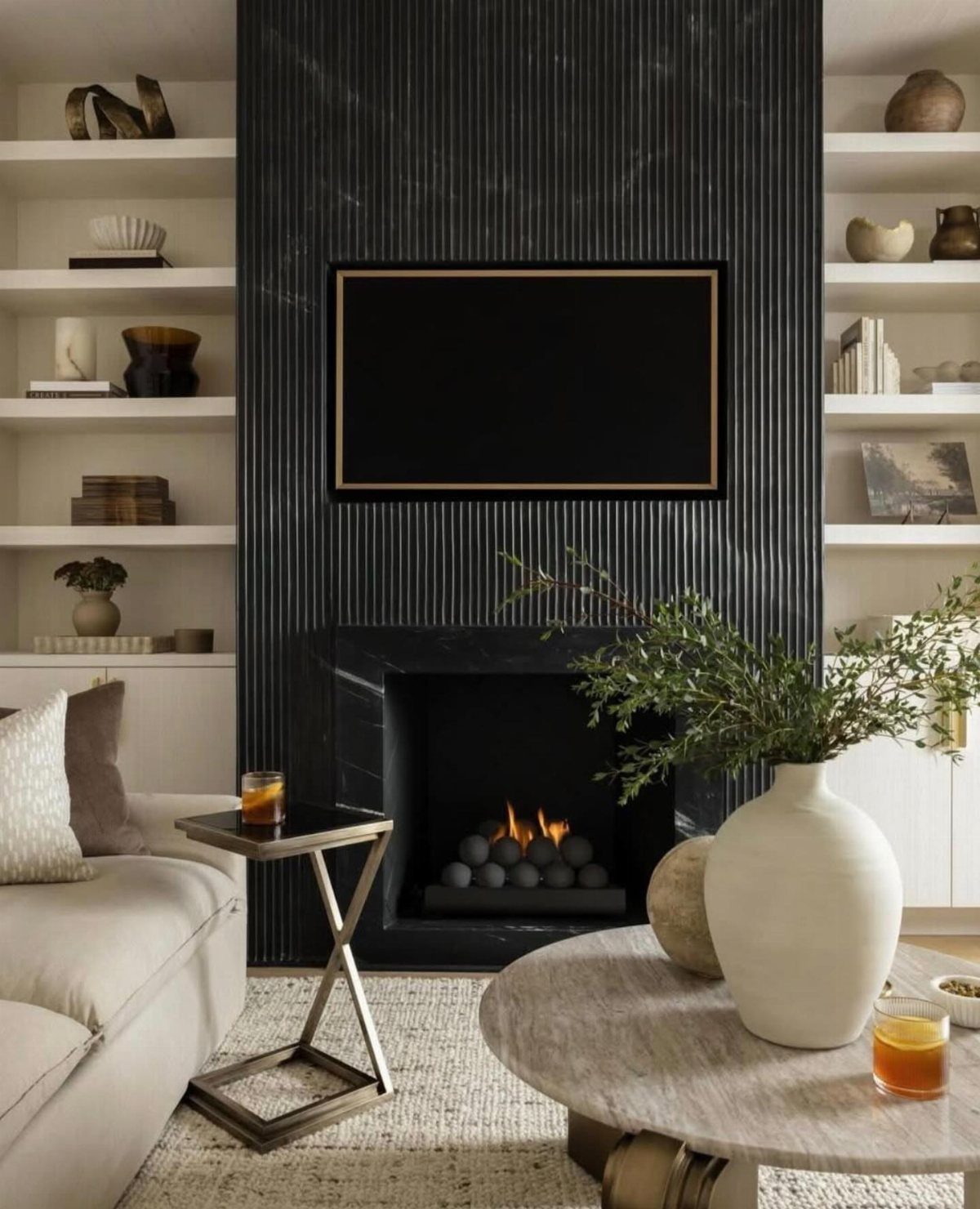 Black fluted accent wall with a mounted TV above a modern black fireplace.