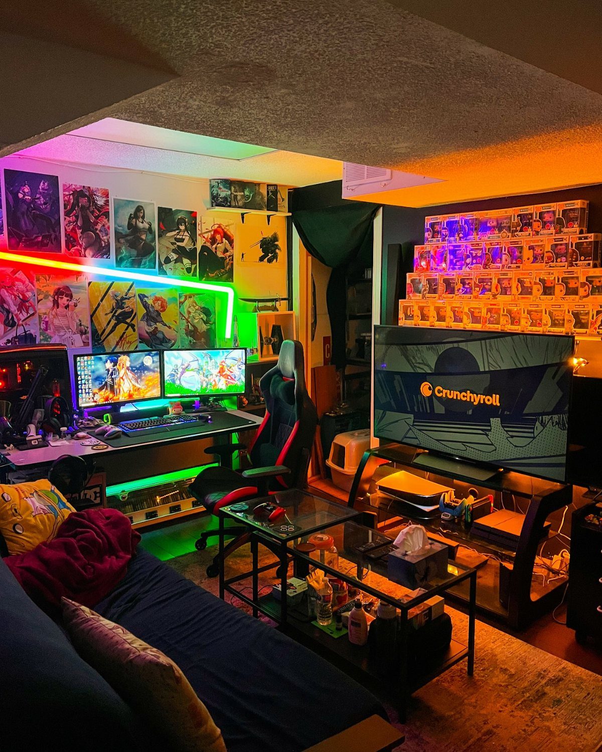 Anime-themed gaming room with dual monitors, character posters, and colorful LED lighting.