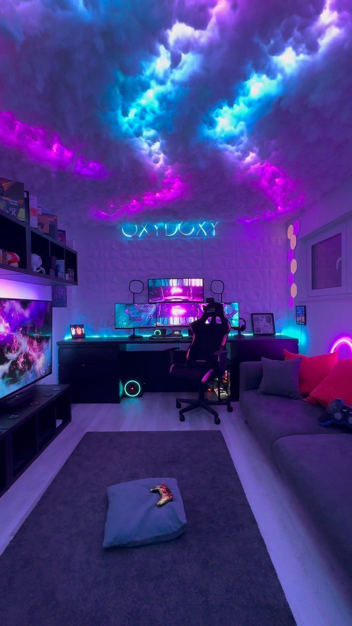 Gaming room with neon purple and blue cloud ceiling, desk setup, and grey sofa.
