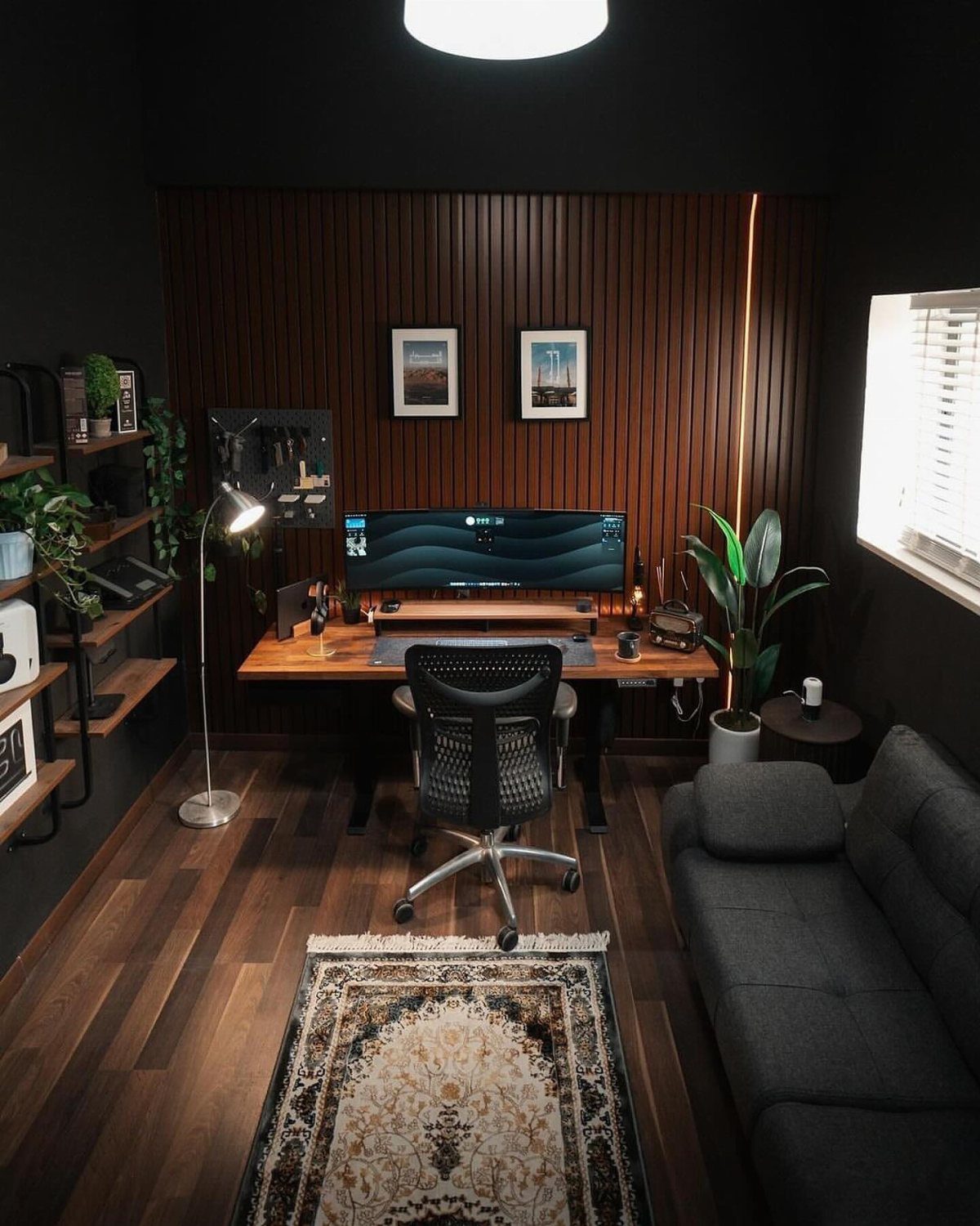 Home office setup with a wooden desk, black chair, and modern floor lamp.