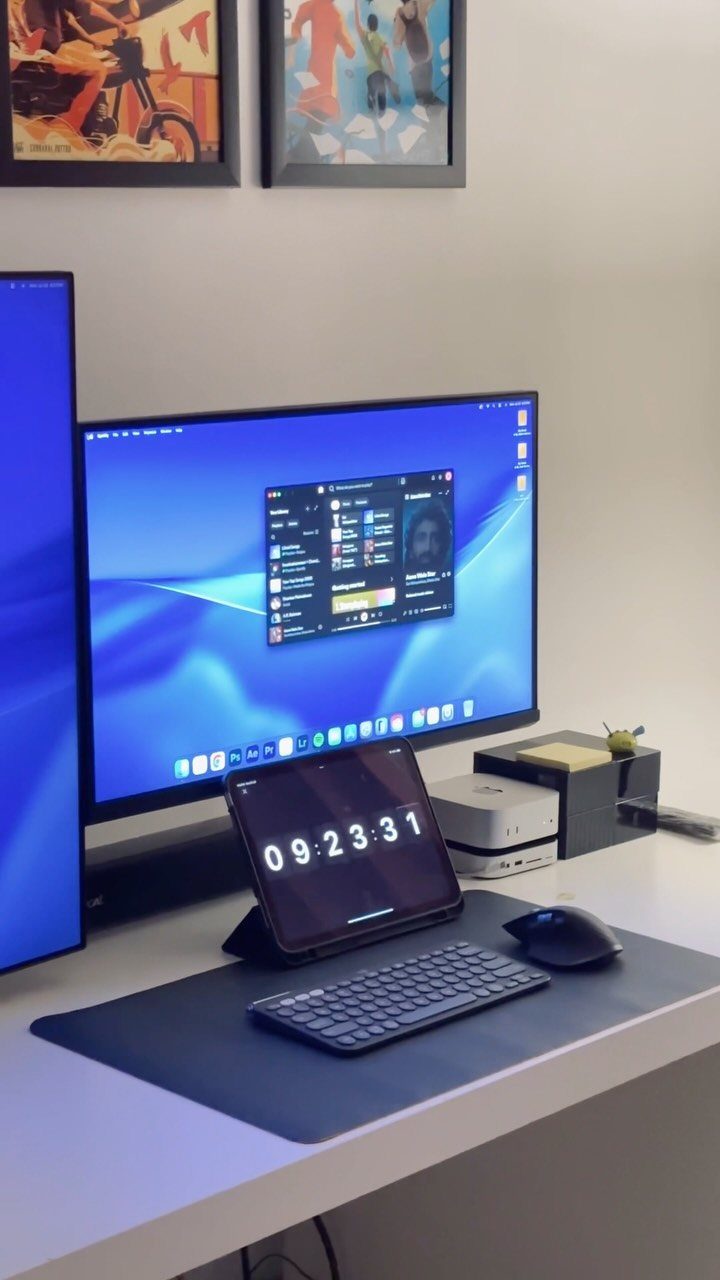 White home office desk with computer monitor, tablet, and framed art on wall