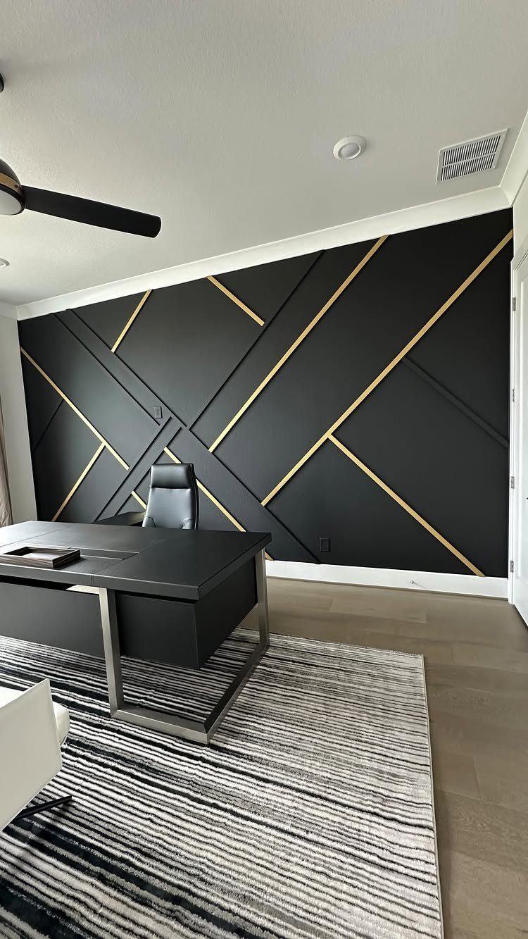 10 Home Office Paint Colors for a Productive Space 4 Black accent wall with gold geometric patterns in a modern home office setting.