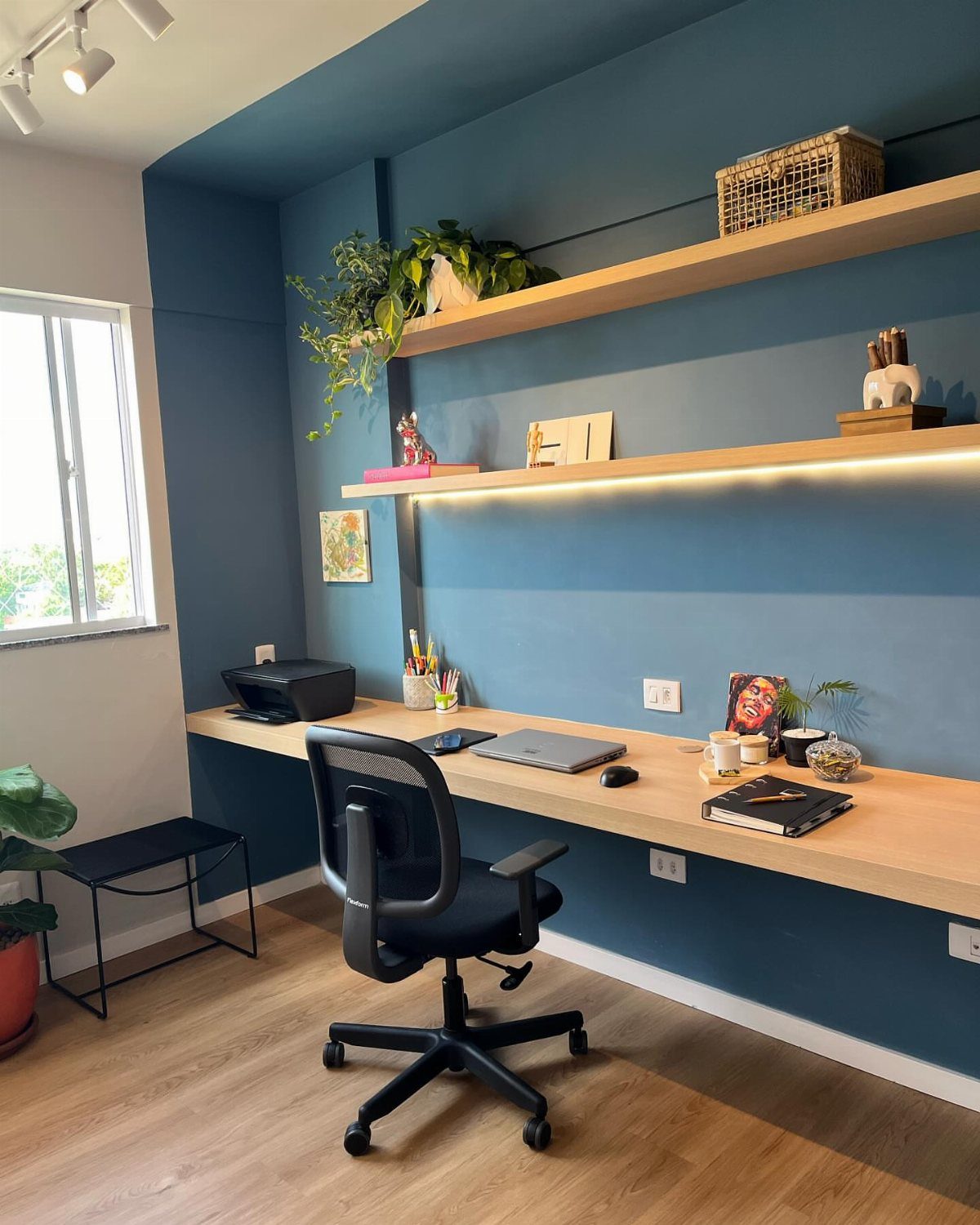 10 Home Office Paint Colors for a Productive Space 7 Home office with deep blue walls, light wood desk, and black ergonomic chair.
