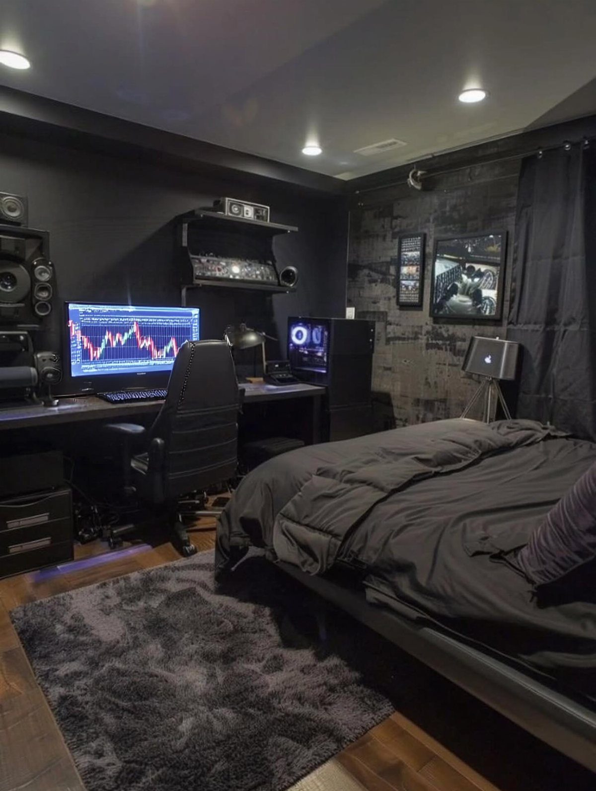 Black walls in a home office and bedroom setup with a dark desk.