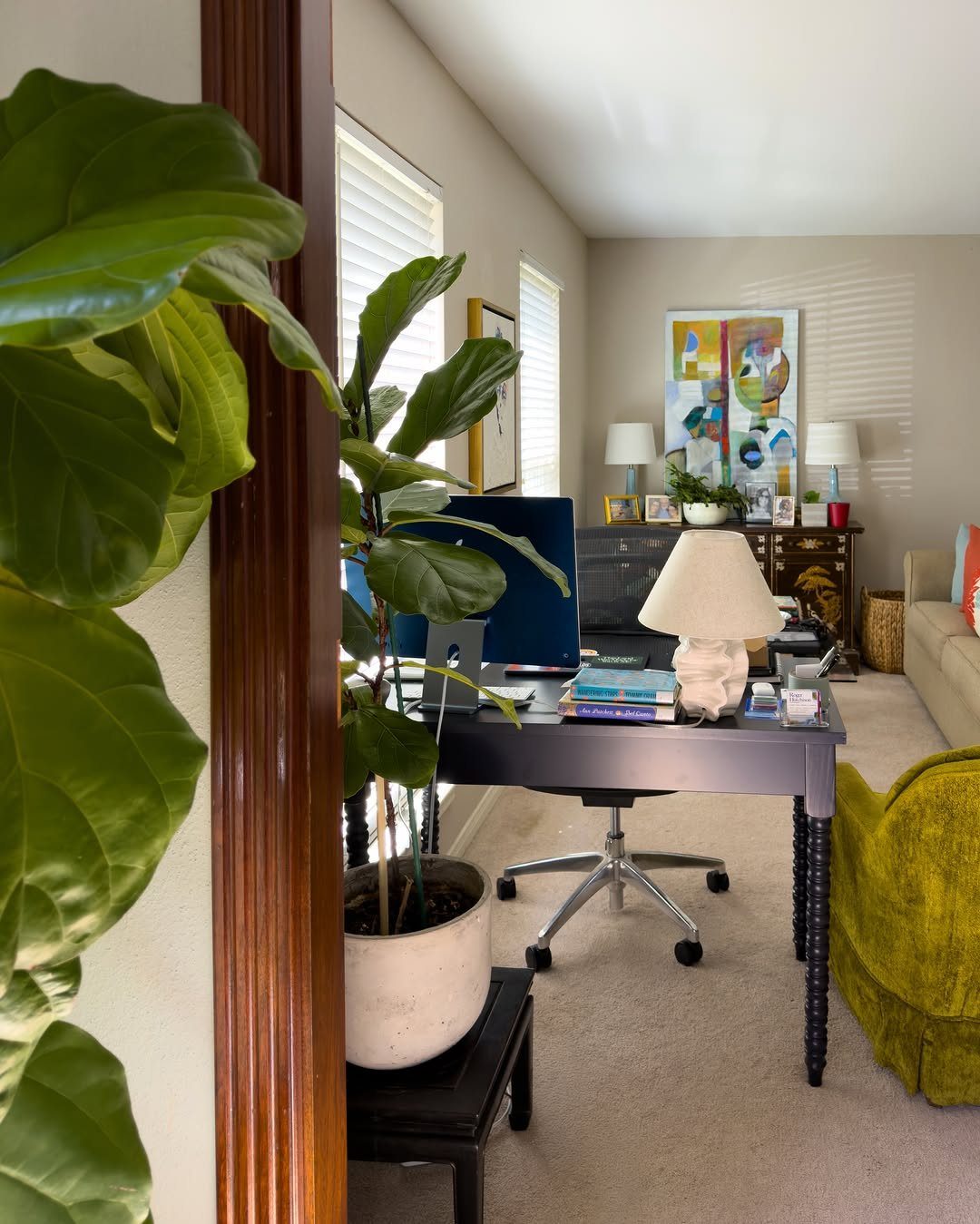Fiddle leaf fig plant in a white pot next to a home office desk.