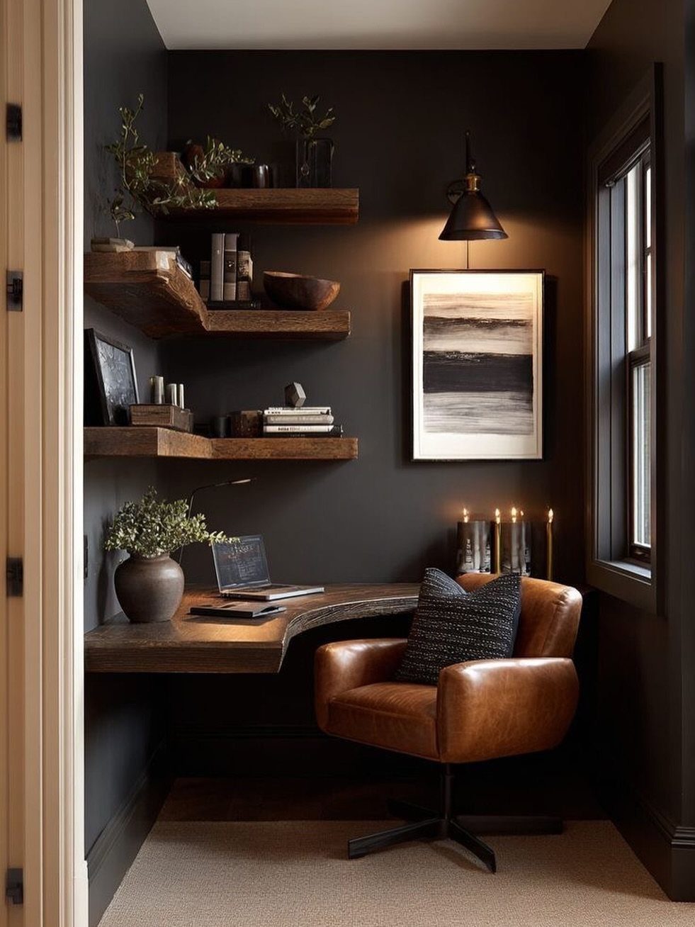 Curved wooden corner desk with leather chair in a dark, moody writing nook.