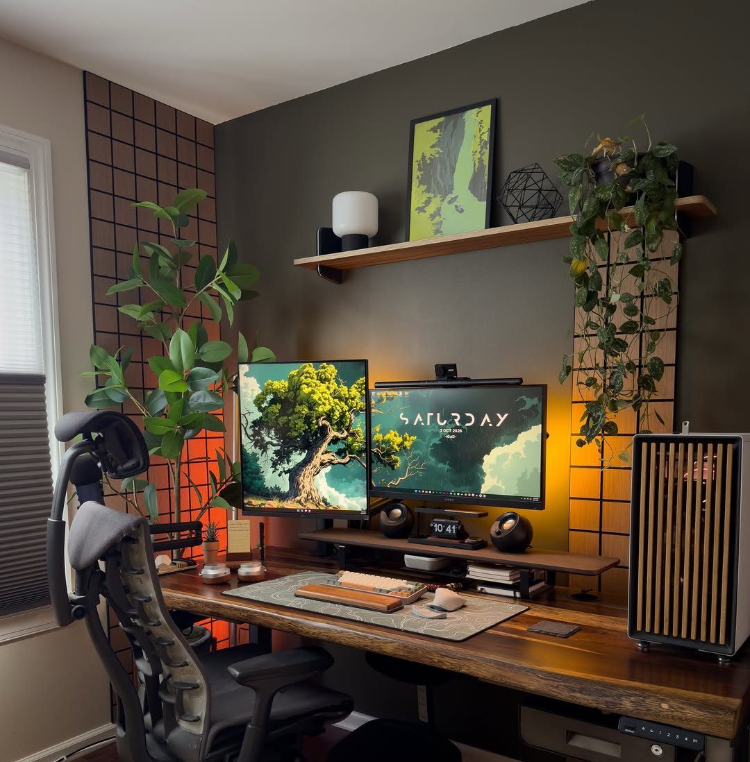 L-shaped corner desk in a home office with dual monitors and a plant.