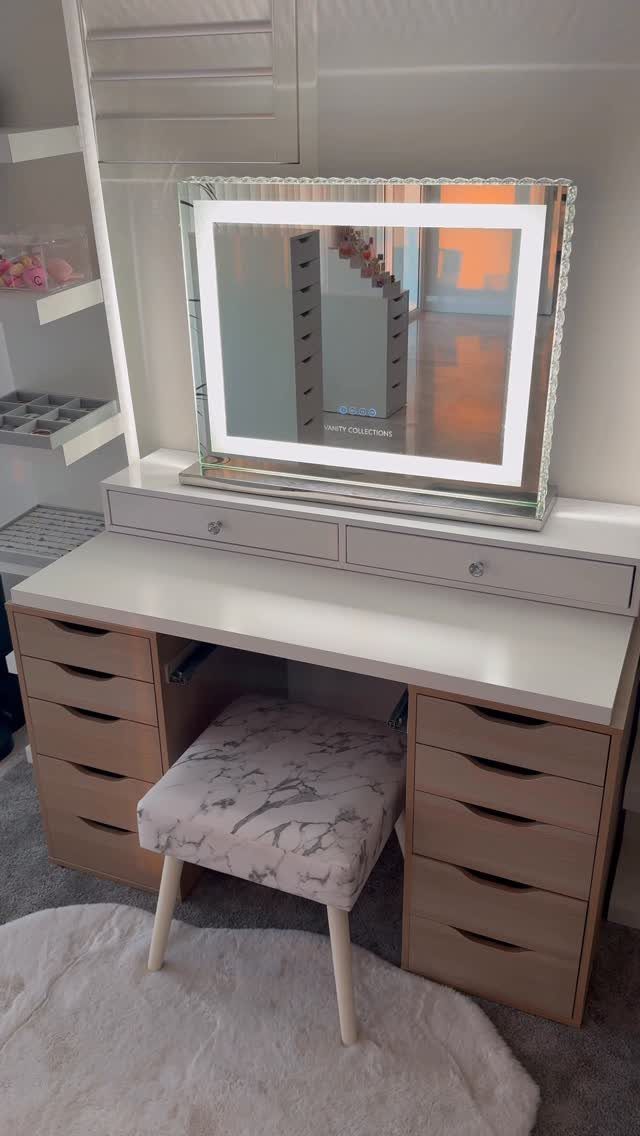 White vanity desk with light brown Alex drawers, illuminated mirror, and marbled stool.