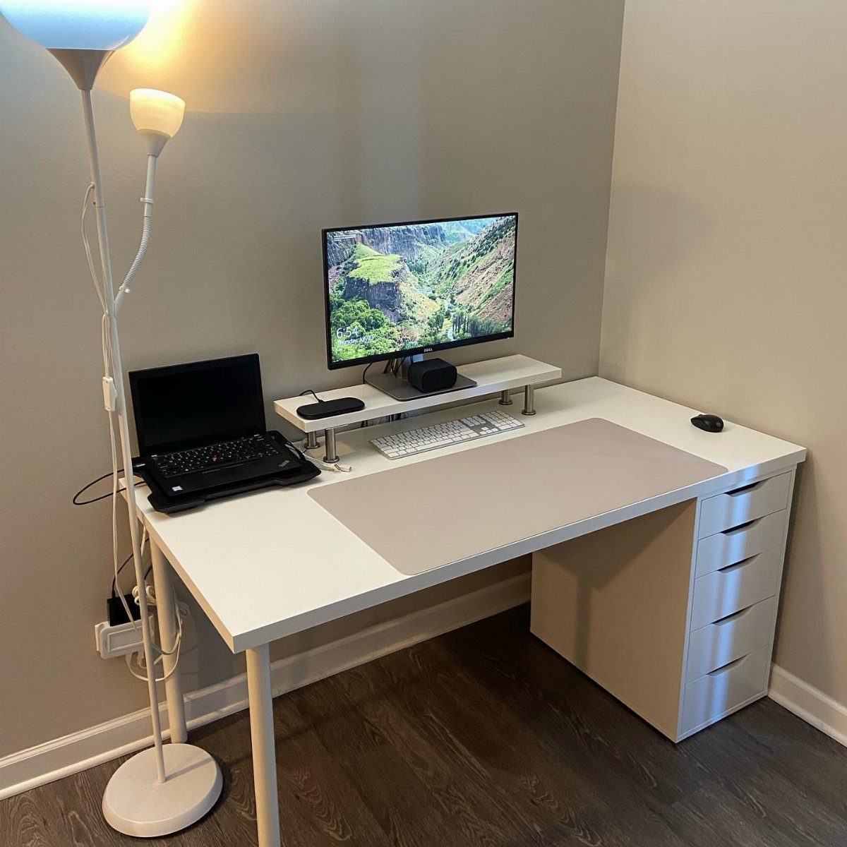 White desk with IKEA Alex drawers, monitor, and laptop in a home office.