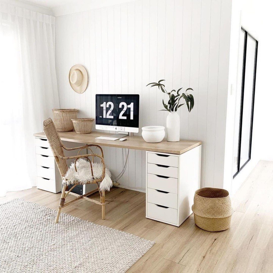 Long light-wood desk with white Alex drawer units and a wicker chair.