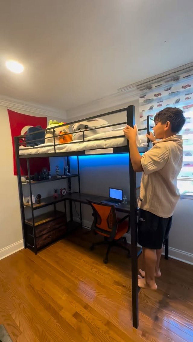 Loft bed with a desk and blue ambient LED lighting in a bedroom.