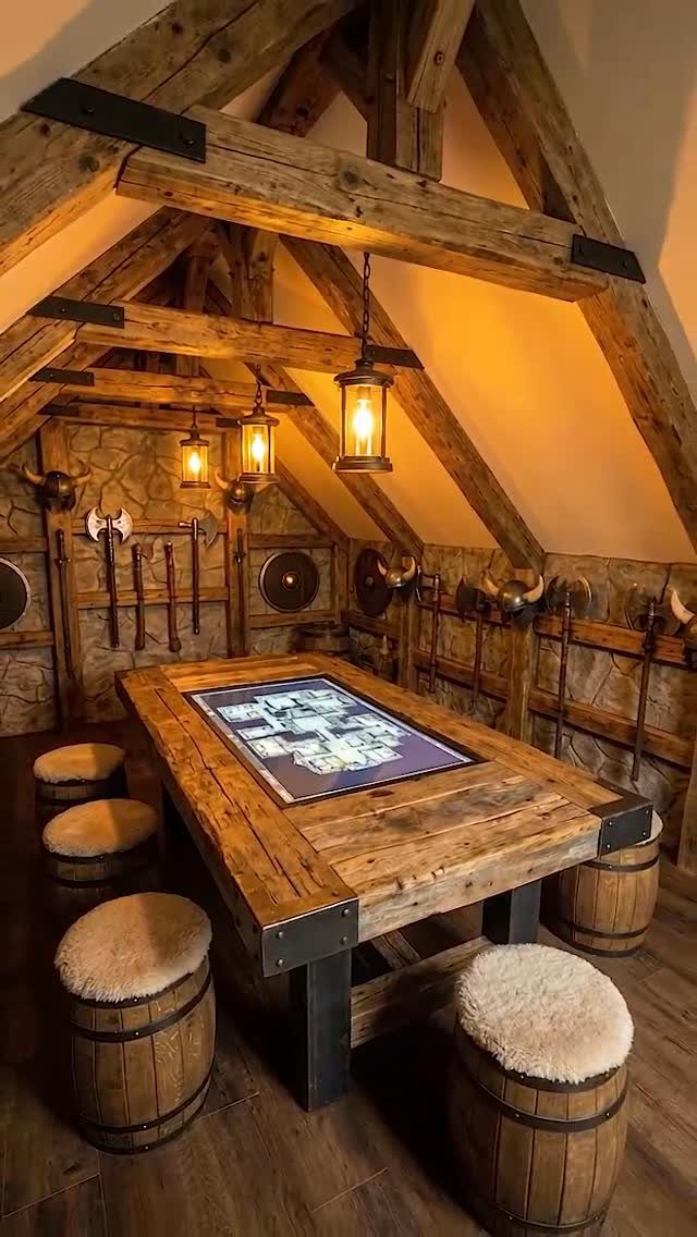 Rustic loft game room with a digital table, barrel stools, and medieval decor.