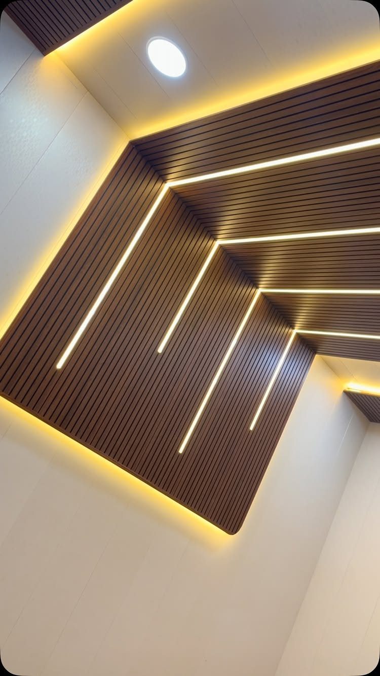 Wooden slat ceiling with integrated linear LED lighting and a recessed spotlight.