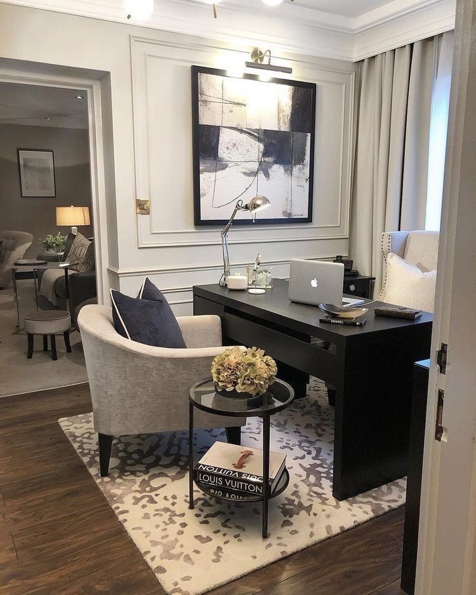 Luxury home office with a black desk and large abstract painting on the wall