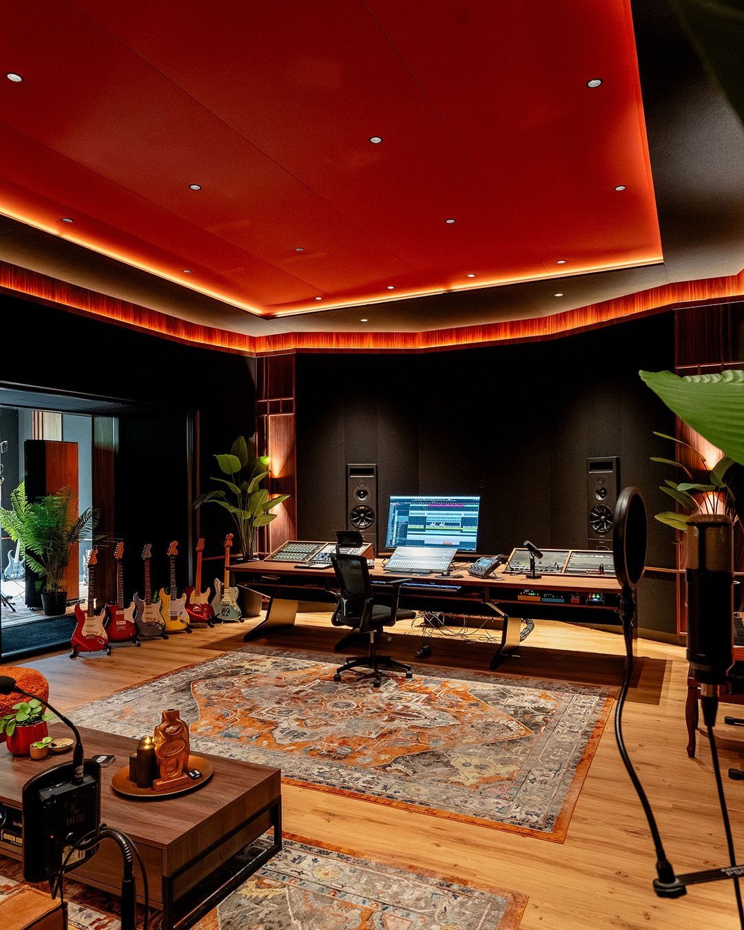 Luxury home music studio with red ceiling, electric guitars, and professional recording equipment.