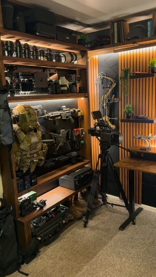 Professional camera gear and tactical equipment displayed on lit wooden shelves in a room.