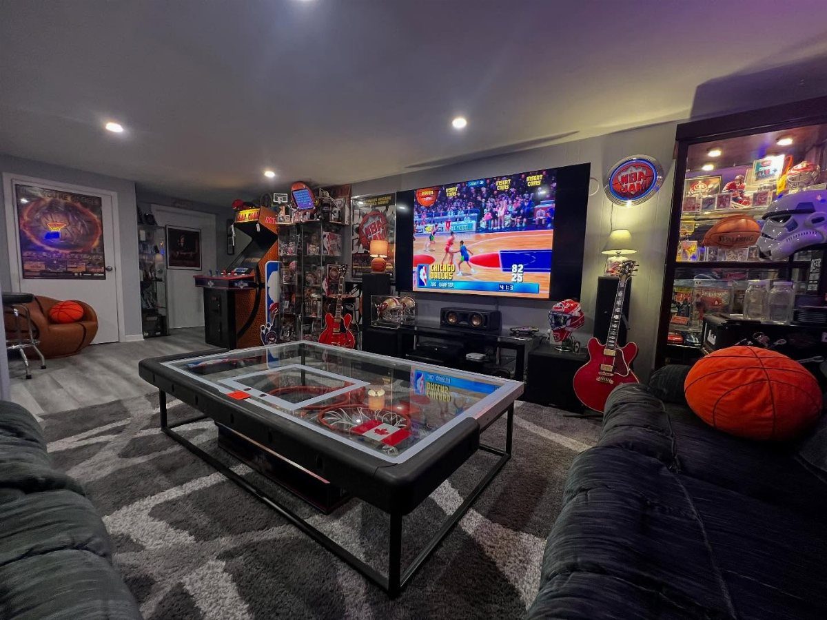Pinball machine and sports memorabilia in a finished basement man cave gaming area