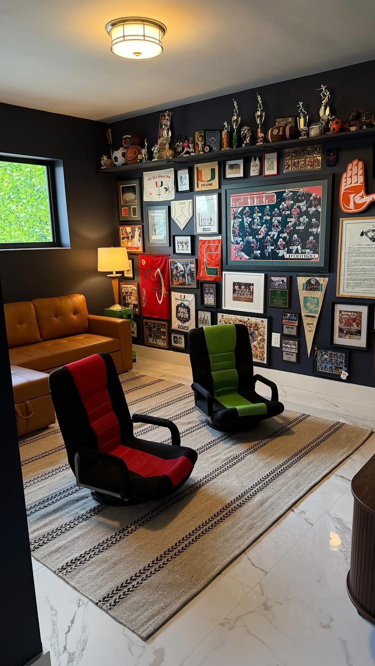 Sports memorabilia wall with framed photos and trophies in a dark themed man cave.
