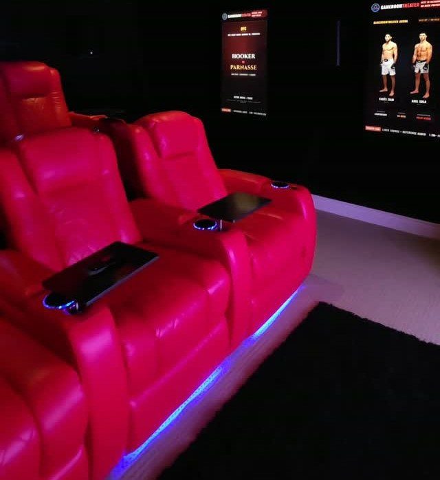 Red leather theater recliners with blue LED accent lighting in a dark room