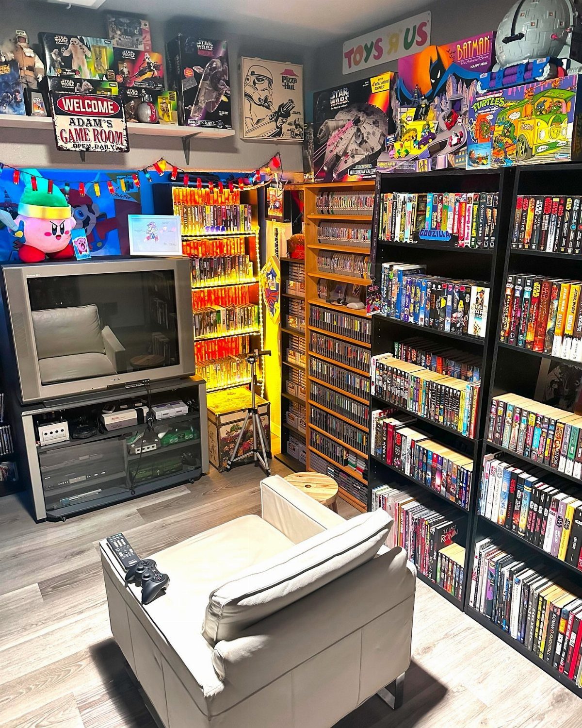 Shelves filled with video game collections in a themed gaming room with a CRT TV.