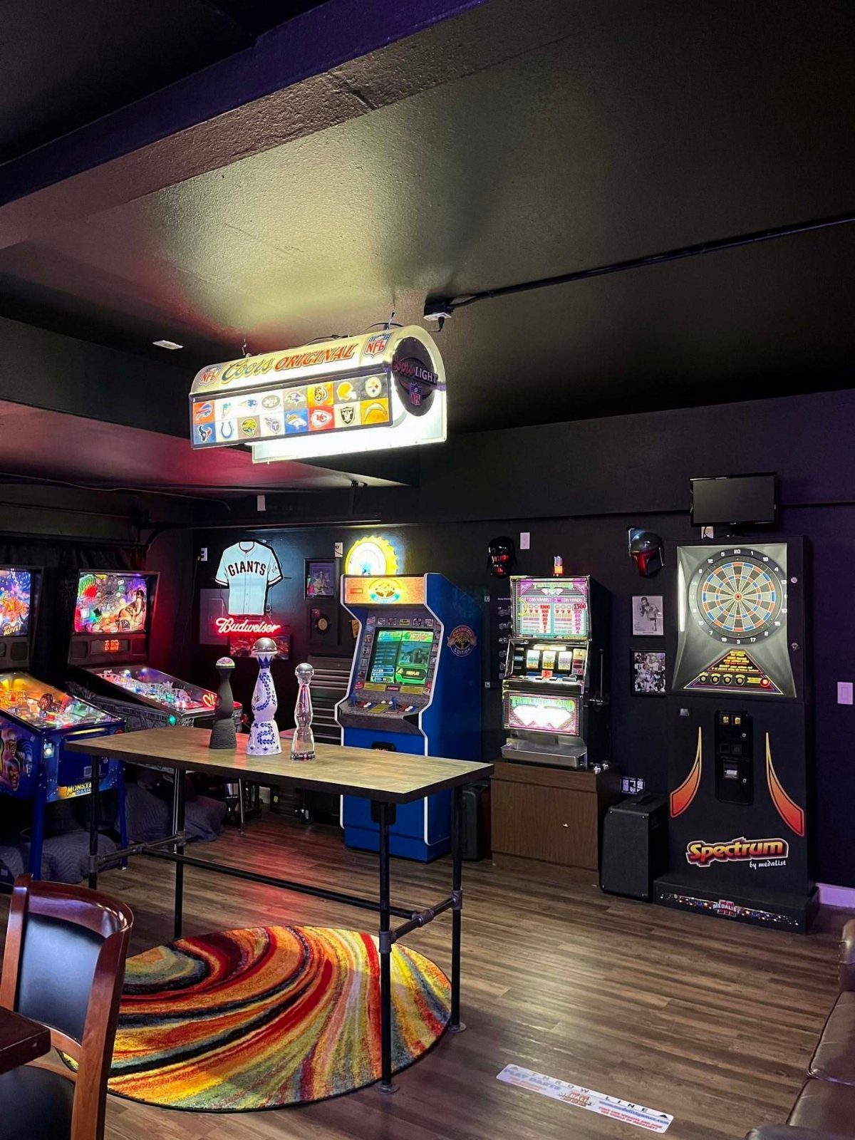 11 Man Cave Must Haves for Your Space 2 Blue arcade game machine and pinball machine in a dark themed man cave.