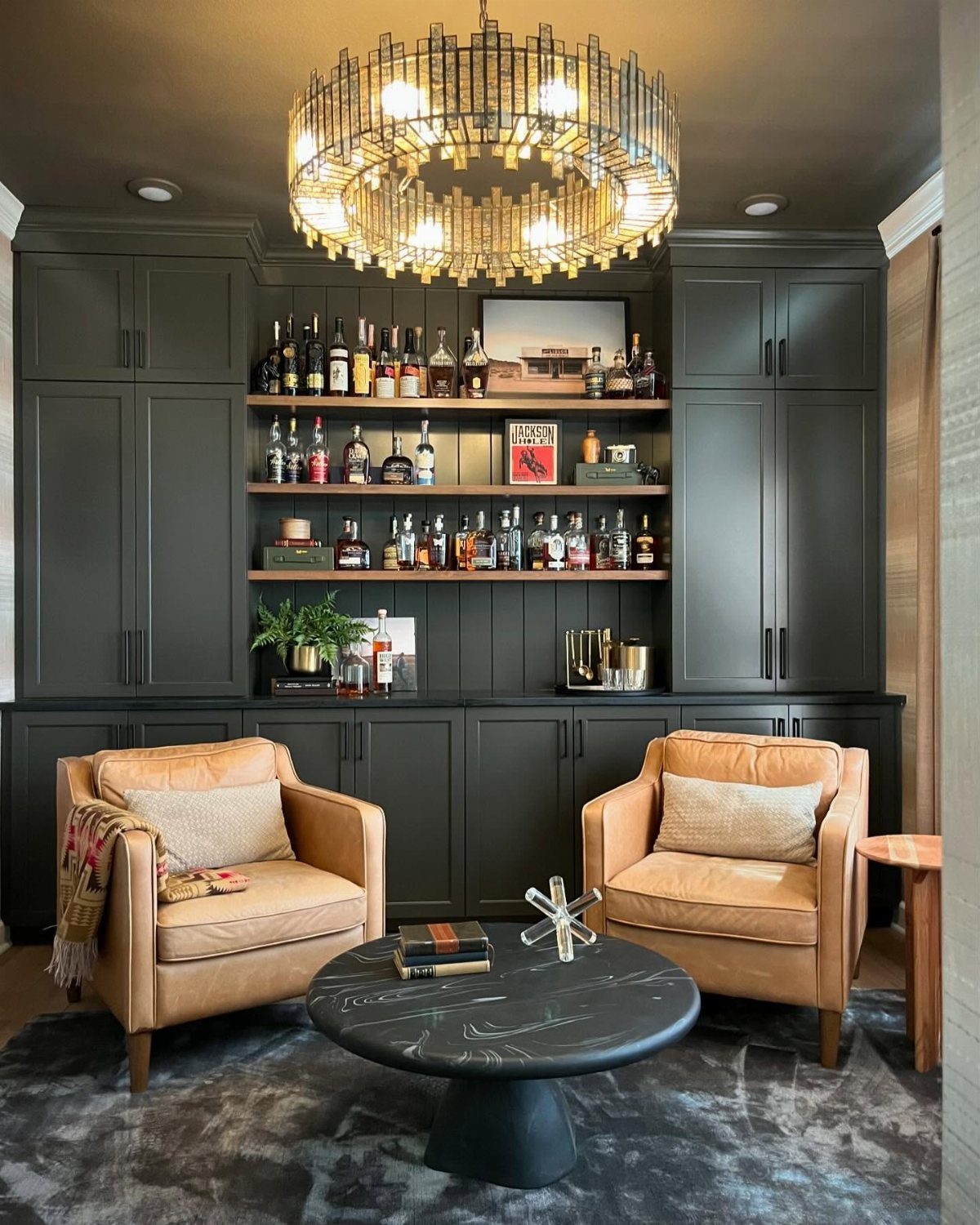 11 Man Cave Must Haves for Your Space 3 Tan leather armchairs and marble table in a lounge with a liquor bar