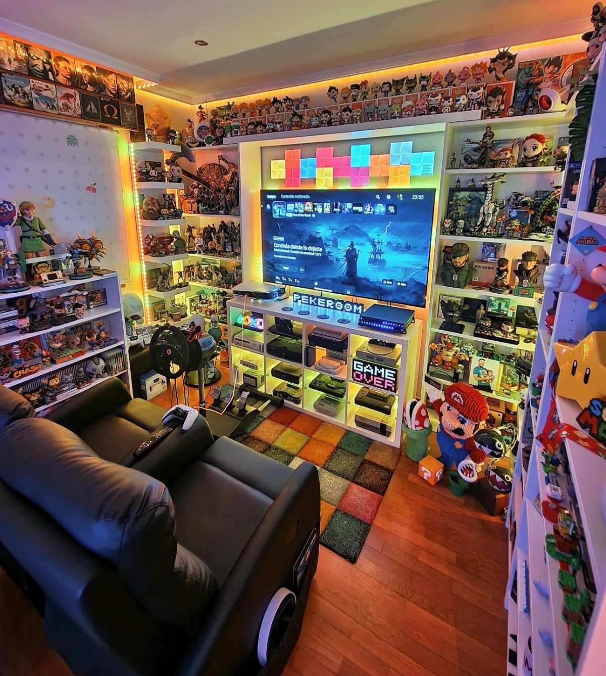 11 Man Cave Must Haves for Your Space 7 Gaming room with a large television, leather chair, and shelves of figurines.