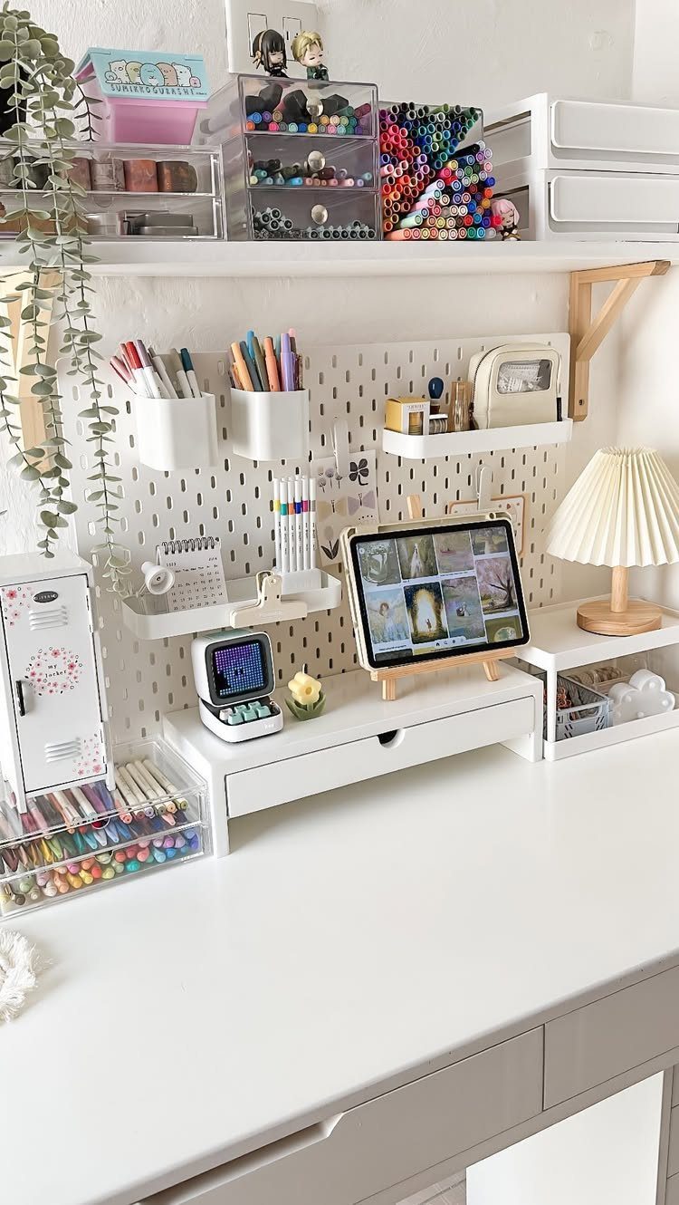 14 Office Decorating Ideas for Work to Refresh Your Space 12 White desk with pegboard organizer, art supplies, tablet, and a small lamp.