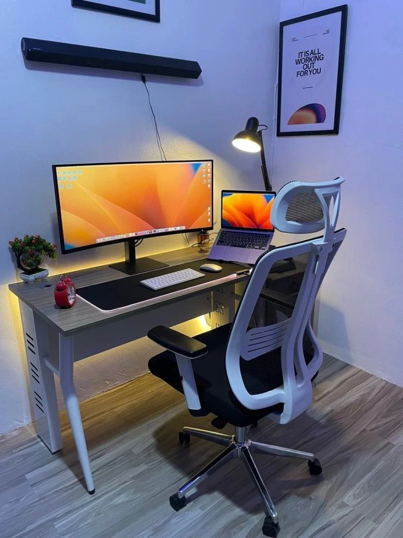 14 Office Decorating Ideas for Work to Refresh Your Space 6 Ergonomic white mesh office chair and grey desk with computer monitors and lamp.