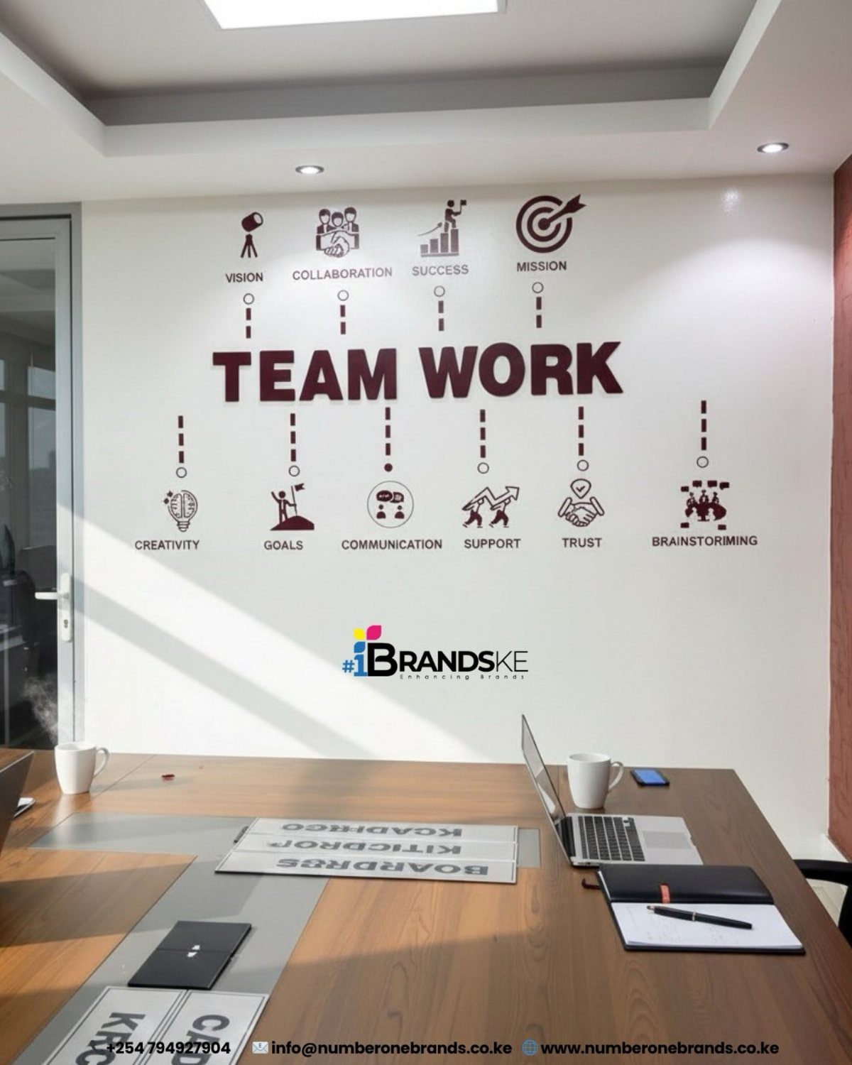 14 Office Decorating Ideas for Work to Refresh Your Space 11 Office wall with Team Work graphic and icons above a wooden desk with laptops.