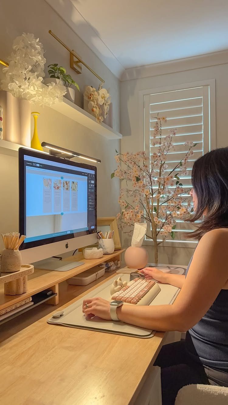 14 Office Decorating Ideas for Work to Refresh Your Space 4 Woman working at a desk with a monitor-mounted LED task light and wall lighting.