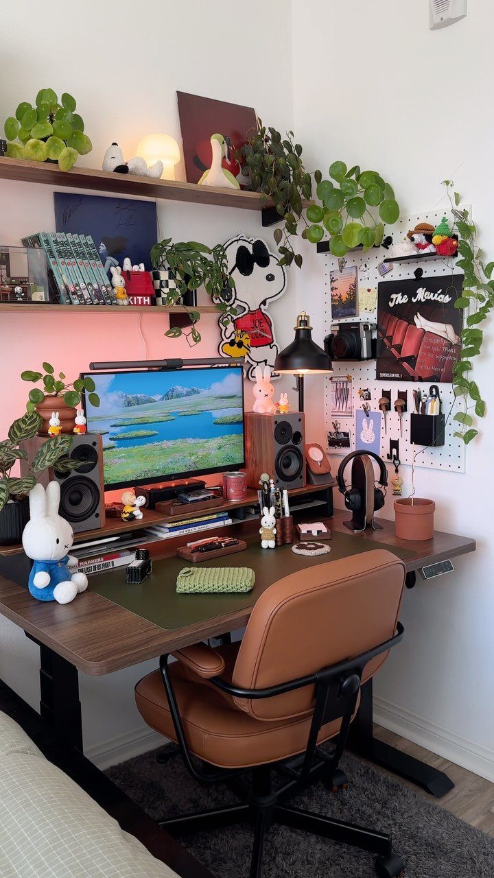 Home office desk with a brown leather chair and various green potted plants.