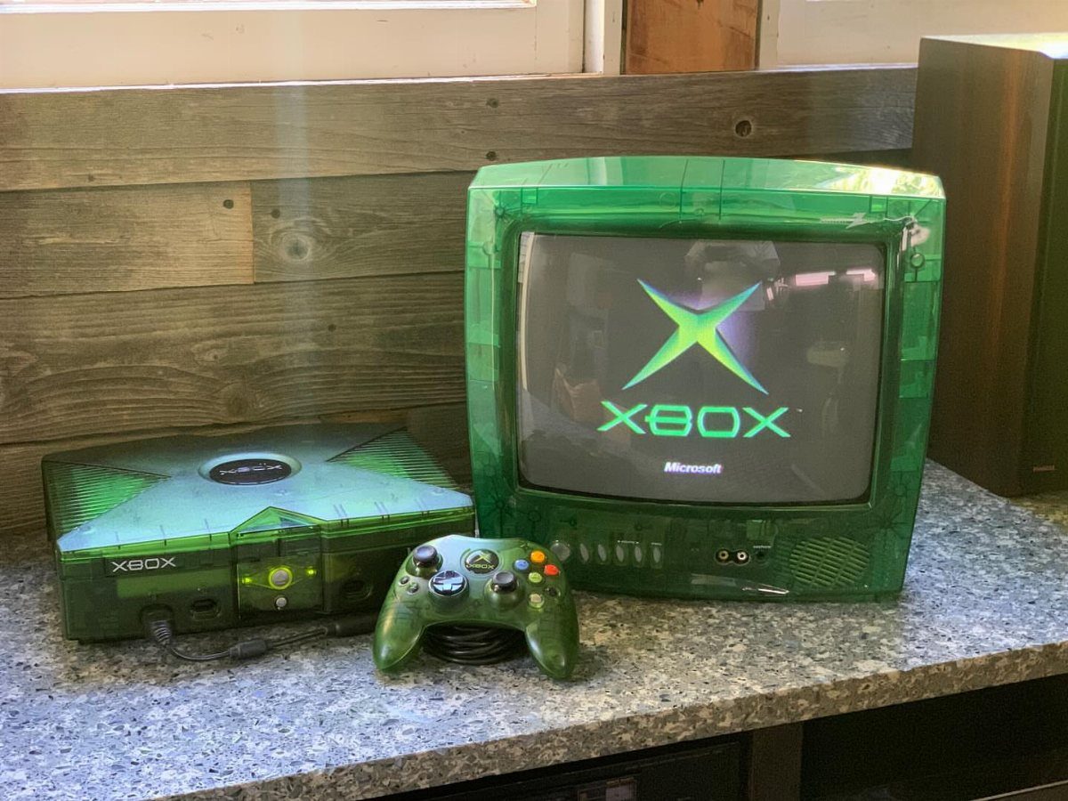 Translucent green Xbox console and matching CRT television on a granite countertop.