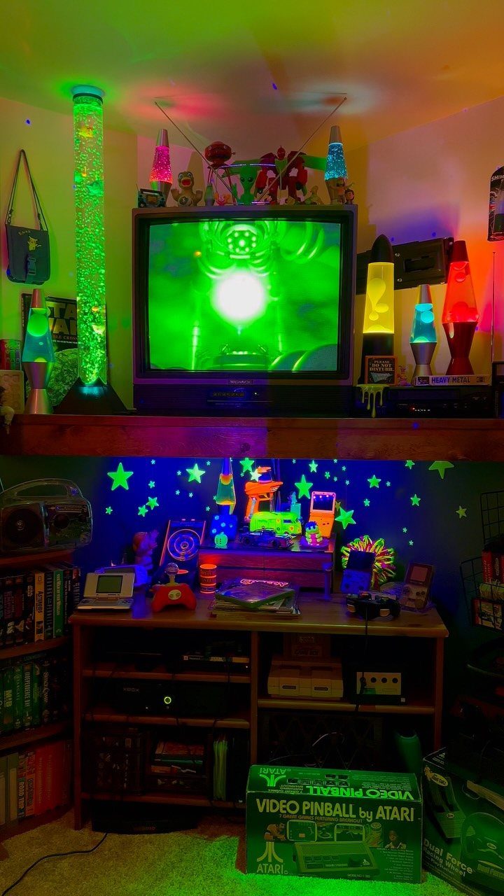 Retro video game room with CRT television, lava lamps, and vintage gaming consoles.