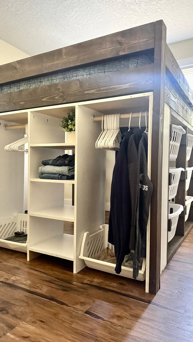 Loft bed with white built-in storage and matching baskets underneath on wood floors