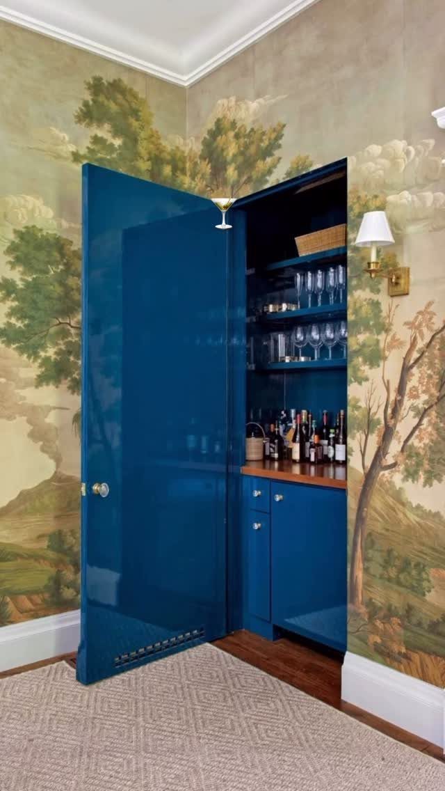 18 Small Bars for Home That Fit Any Space 7 Blue built-in home bar cabinet with glassware and liquor against landscape wallpaper